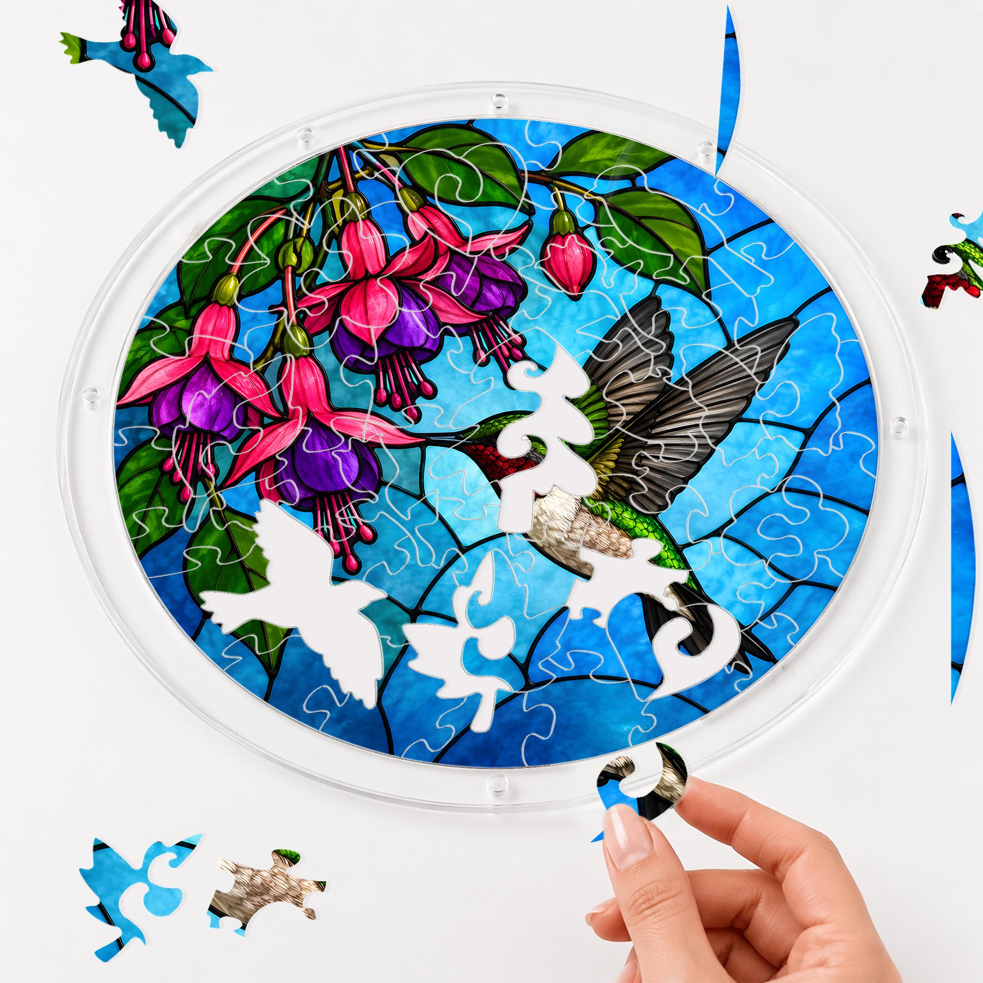 Hand assembling a hummingbird fuchsia flower acrylic puzzle suncatcher with colorful puzzle pieces