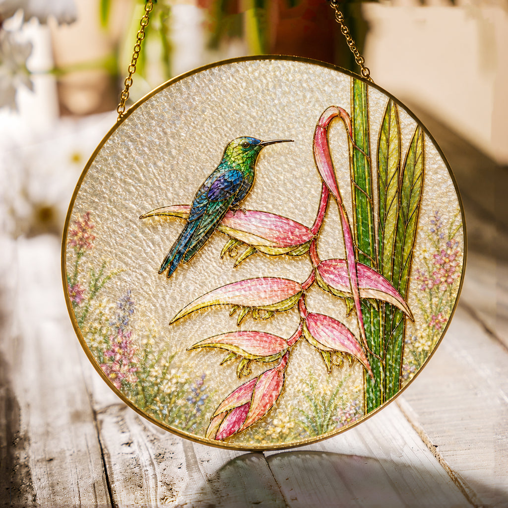 Hummingbird and pink heliconia stained glass suncatcher with gold frame on a white background