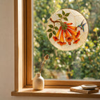 Hummingbird trumpet flower suncatcher in a bright window