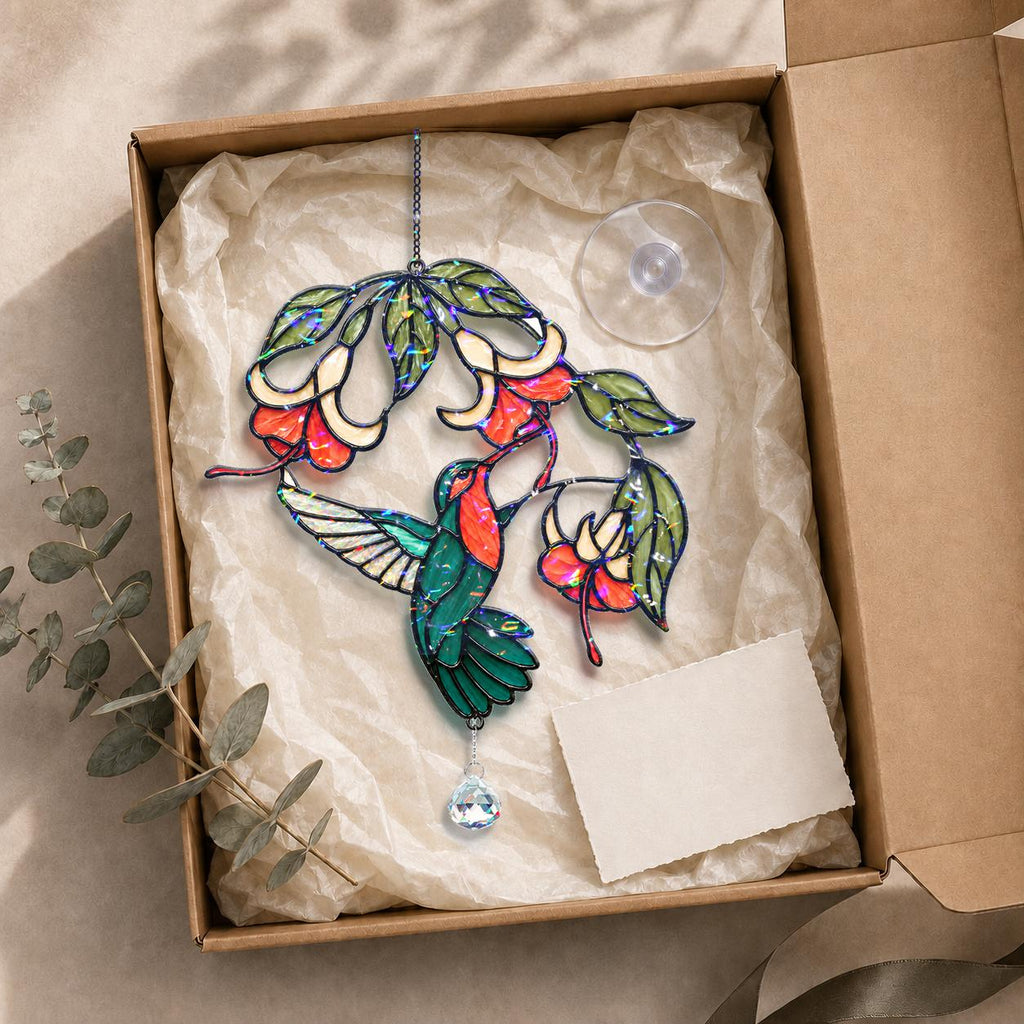 Hummingbird fuchsia flower holographic acrylic suncatcher displayed in a kraft gift box with tissue paper and adhesive hook.
