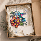 Hummingbird hibiscus holographic acrylic suncatcher displayed in a kraft gift box with tissue paper and adhesive hook.
