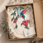 Hummingbird flower holographic acrylic suncatcher displayed in a kraft gift box with tissue paper.