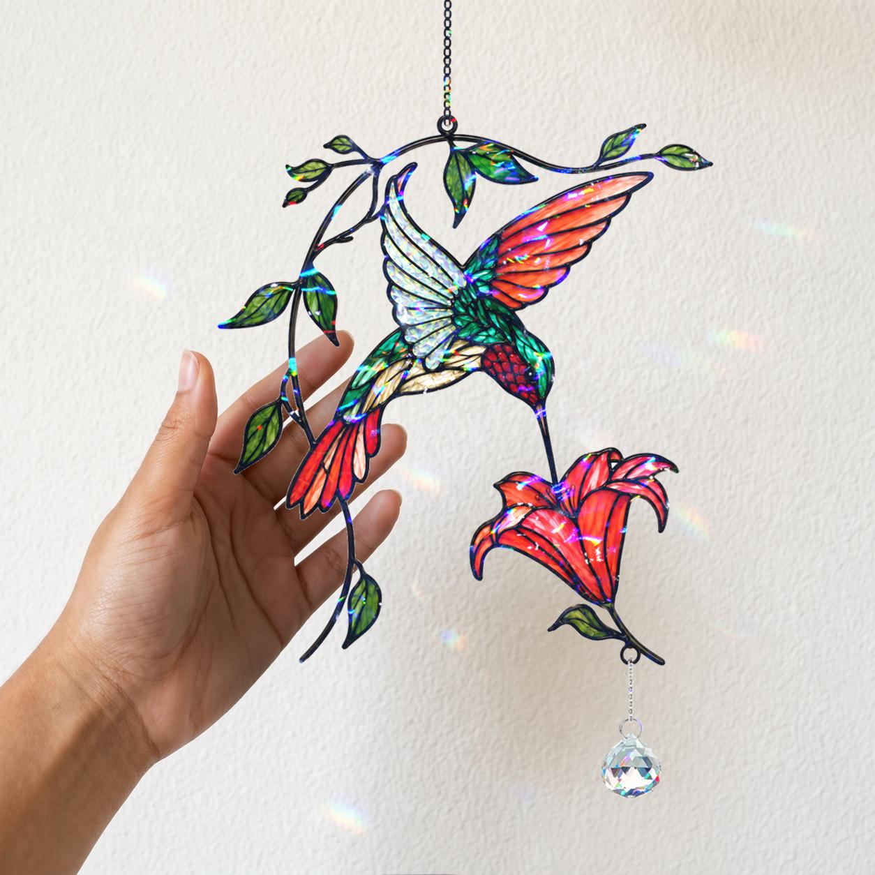 Woman holding a colorful hummingbird holographic acrylic suncatcher with red flower and crystal charm.