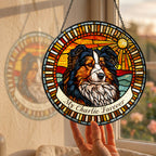 Personalized dog memorial suncatcher held by a sunny window with a garden view