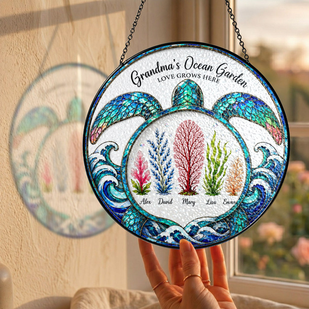 Hand holding the personalized Grandma's Ocean Garden turtle suncatcher by a window