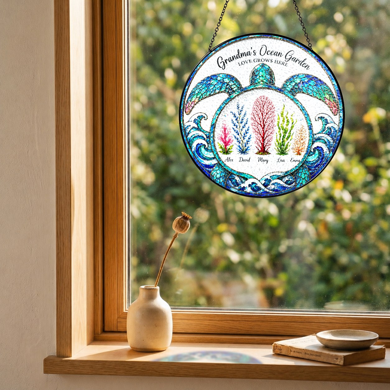 Turtle suncatcher with custom names hanging in a wooden window frame