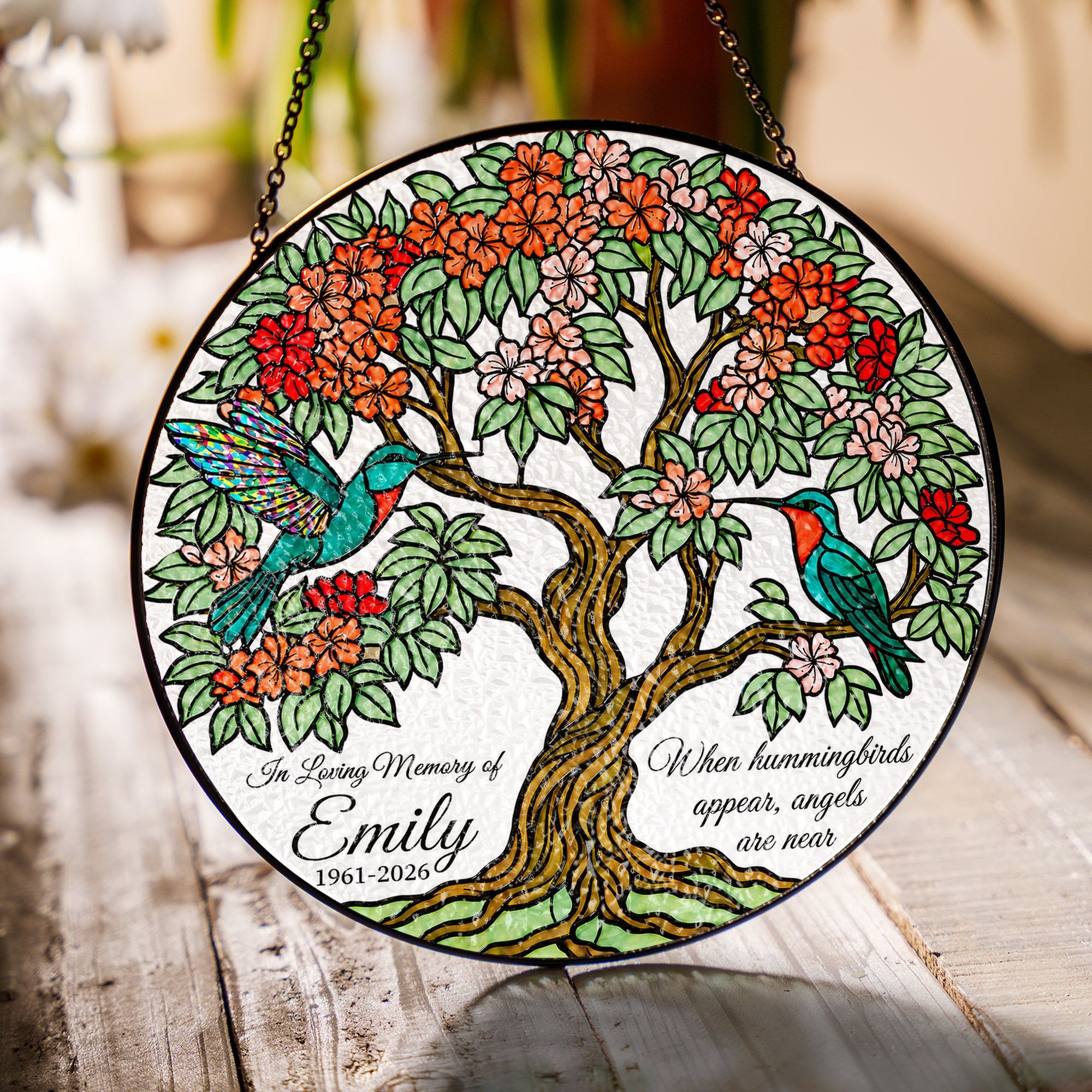 Hummingbird tree of life memorial suncatcher in a bright window with soft daylight