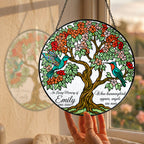 Hummingbird tree of life memorial suncatcher hanging in a sunny window with a garden view