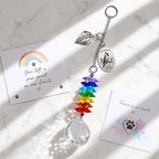 Hand holding personalized cardinal memorial crystal suncatcher outdoors with custom Dad oval charm, silver leaf charm, rainbow crystals, and sparkling crystal ball