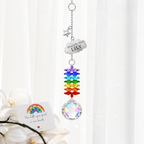 Personalized memorial cloud star crystal suncatcher hanging in front of sheer curtains with Rainbow Bridge sympathy card and soft floral decor