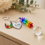 Personalized dog memorial crystal suncatcher with rainbow crescent dog charm, custom Buddy heart charm, rainbow crystals, and clear crystal ball on a wooden tabletop