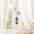 Personalized dog memorial moon crystal suncatcher hanging by a bright window with custom paw charm, rainbow crystals, and clear crystal ball