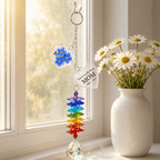 Personalized forget me not memorial crystal suncatcher hanging by a sunny window with blue flower charm, custom MOM star charm, rainbow crystals, and clear crystal ball