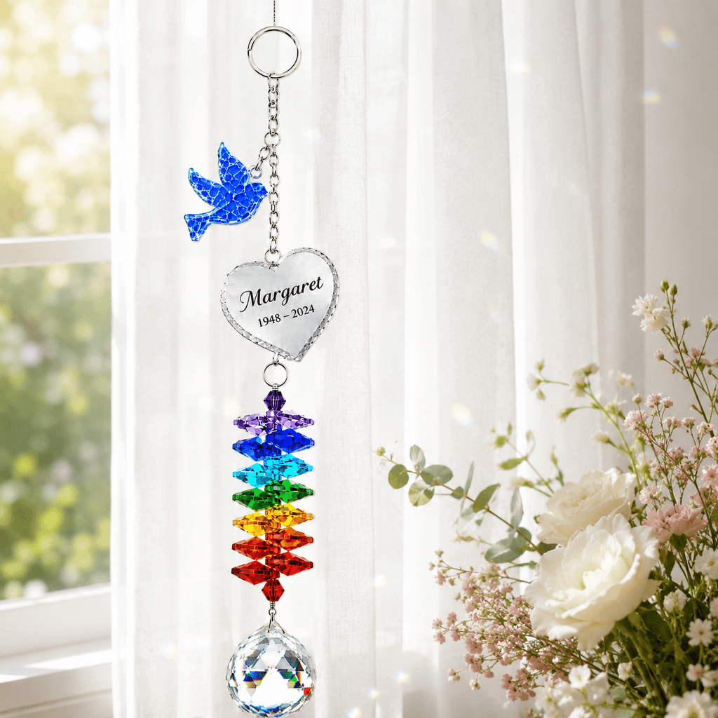 Personalized memorial dove crystal suncatcher hanging by a bright window with custom Margaret heart charm, rainbow crystals, and clear crystal ball