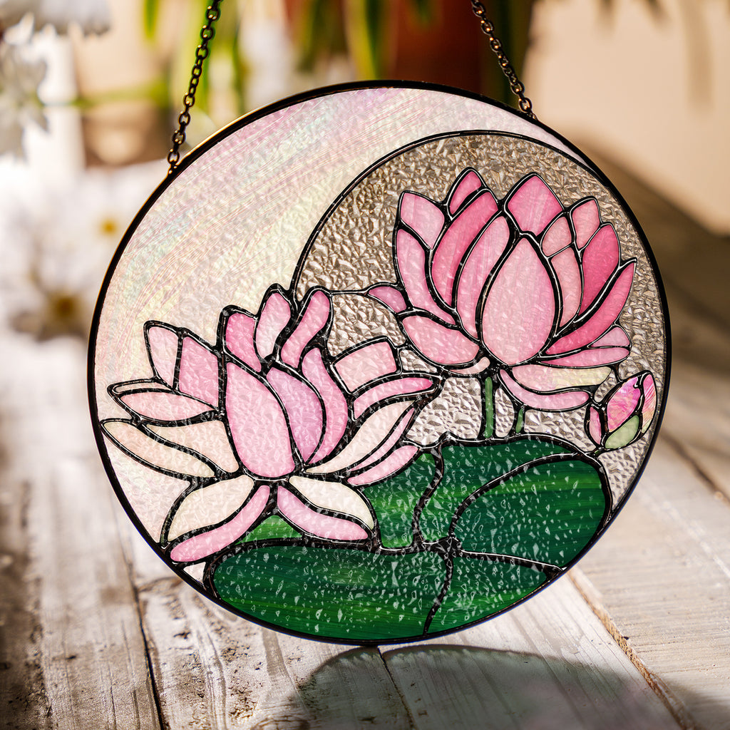 Pink lotus stained glass suncatcher in a bright window with soft daylight