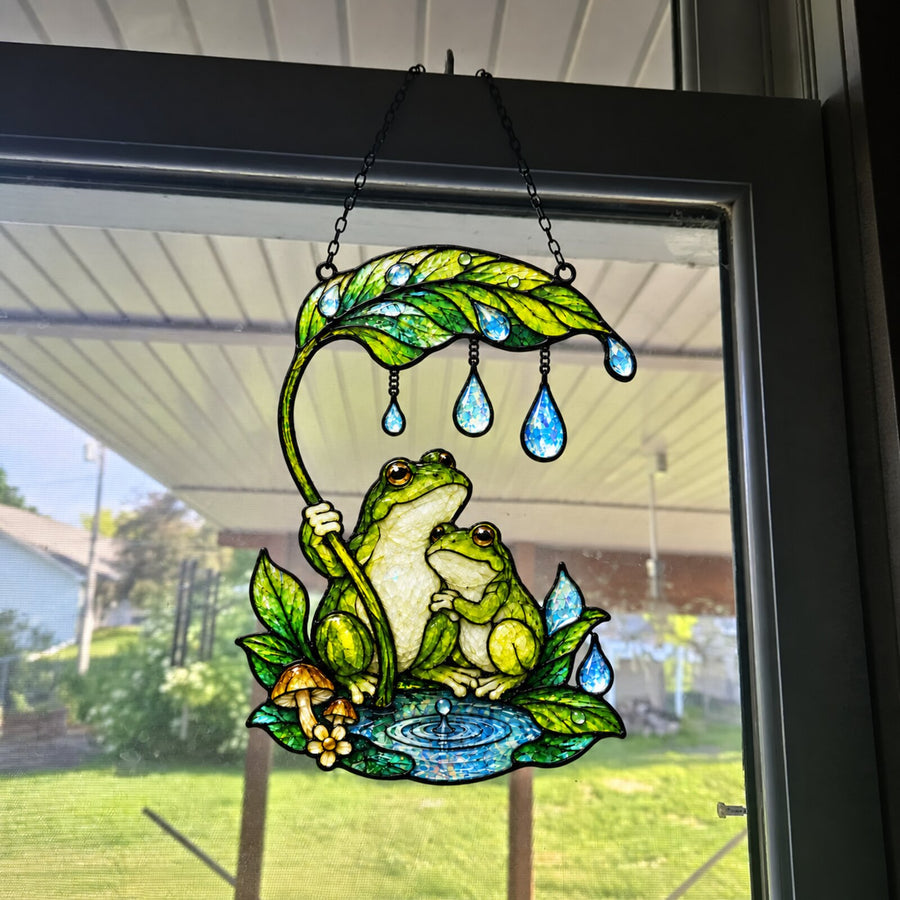 Frog Couple & Leaf Umbrella suncatcher on a porch screen door