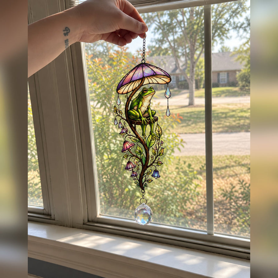 Frog & Mushroom Umbrella suncatcher hung in a front window