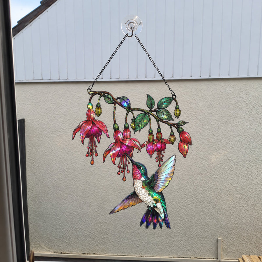 Fuchsia Hummingbird suncatcher on a window facing the house wall