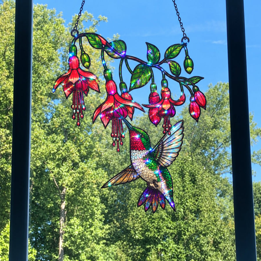 Fuchsia Hummingbird suncatcher against blue sky and trees