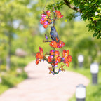 Robin and orange trumpet flower holographic suncatcher catching sunlight and casting rainbow reflections in a window