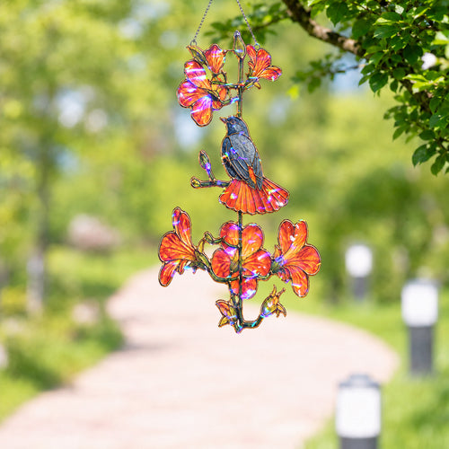 Robin and orange trumpet flower holographic suncatcher catching sunlight and casting rainbow reflections in a window