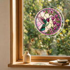 Roseglow Hummingbird Garden acrylic puzzle suncatcher displayed in a cozy wooden window corner with soft daylight.