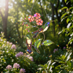 Stained glass style suncatcher with two hummingbirds on a pink blossom branch, hanging in a sunlit window with rainbow light