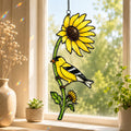 Stained glass style suncatcher with an American goldfinch on a sunflower stem, hanging in a sunlit window with rainbow light