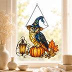 Witch Hat Owl on Pumpkin window suncatcher seen against a sunlit garden