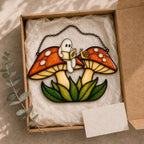 Two Ghosts on Red Mushrooms acrylic suncatcher in a warm, softly lit interior