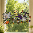 Ghosts and Ravens under the Harvest Moon window suncatcher seen against a sunlit garden