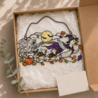 Ghosts and Ravens under the Harvest Moon suncatcher beside a window with seasonal decor
