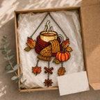 Cozy Autumn Coffee Mug with Pumpkins acrylic suncatcher hanging in a window with seasonal decor