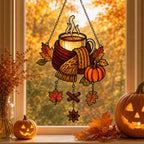 Cozy Autumn Coffee Mug with Pumpkins suncatcher on its metal hanging chain in a bright window
