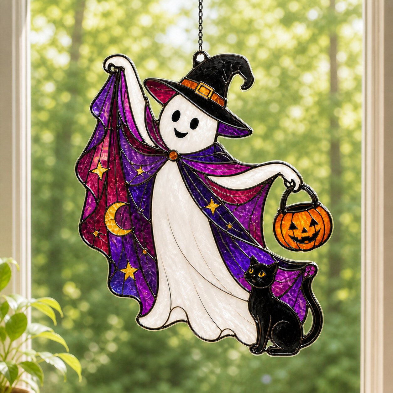 Trick-or-Treat Ghost with Pumpkin Bucket suncatcher on its metal hanging chain in a bright window