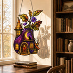Purple Witch Cottage with Crescent Moon suncatcher on its metal hanging chain in a bright window