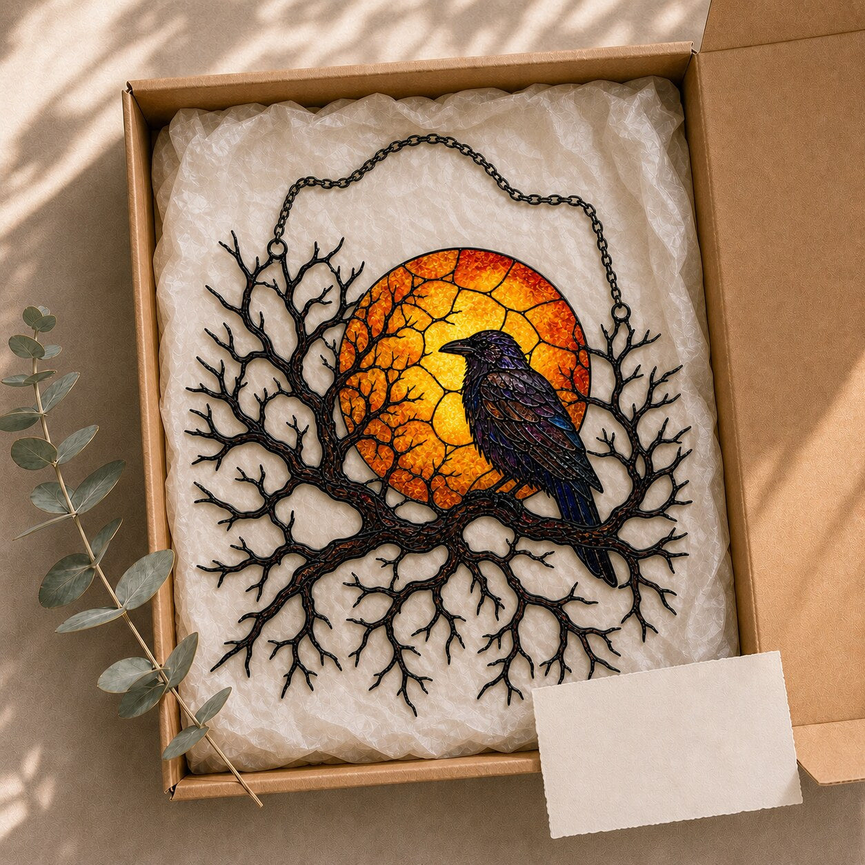 Raven on Branch with Harvest Moon suncatcher catching afternoon light in a home window