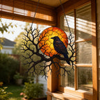 Raven on Branch with Harvest Moon window suncatcher seen against a sunlit garden
