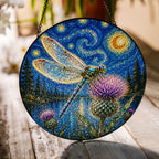Dragonfly thistle suncatcher on a wooden table in sunlight