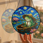 Hand holding the fishing frog suncatcher at a window