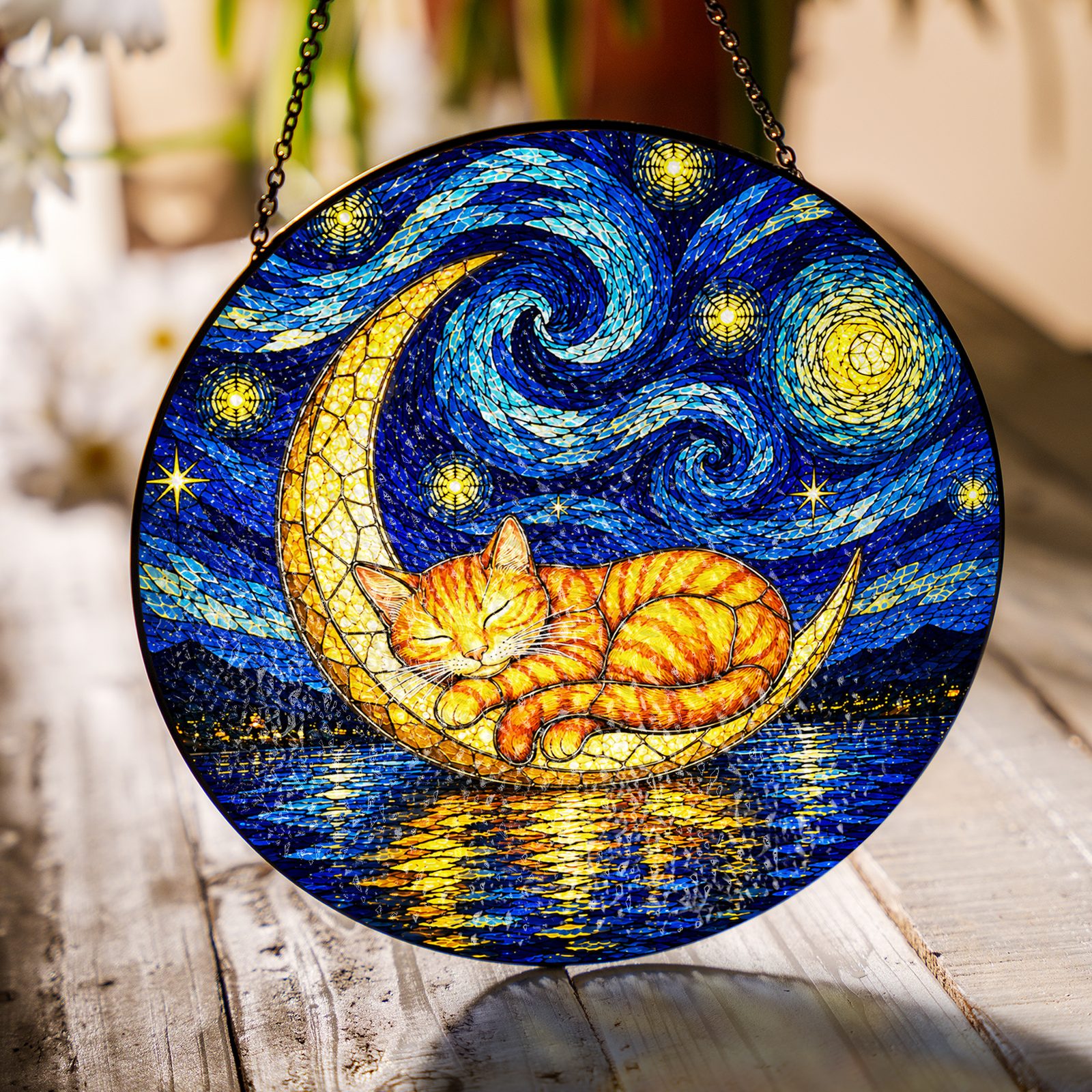 Cat on crescent moon suncatcher on a wooden table in sunlight