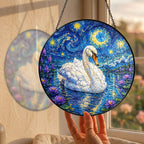 Hand holding the swan suncatcher at a window