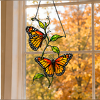 Twin monarch butterflies suncatcher in an autumn window