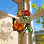Orange butterflies red blossom suncatcher on a bright blue sky window