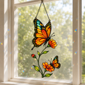 Monarch butterfly and orange cosmos holographic acrylic suncatcher in a sunlit window