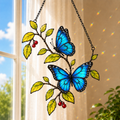 Blue morpho butterflies and berry branch holographic acrylic suncatcher in a sunlit window