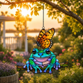 Frog and monarch butterfly suncatcher in a garden at sunset