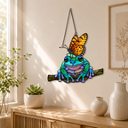 Frog and monarch butterfly suncatcher on a wooden console