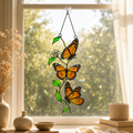 Monarch butterfly trio and flowering vine holographic acrylic suncatcher in a sunlit window