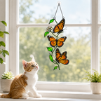 Cat admiring monarch butterfly trio suncatcher on a windowsill